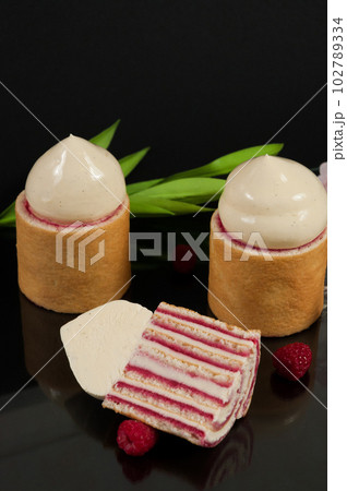 raspberry and creamy ganache cake on a black background raspberry and creamy ganache cake on a black background 102789334