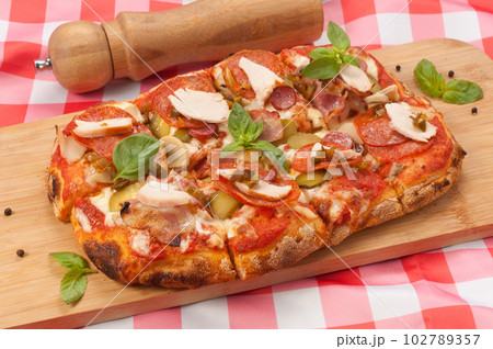 italian pizza with pepperoni, bacon, chicken and mushrooms 102789357