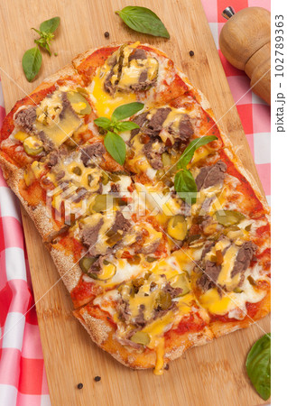 pizza with beef gherkins and jalapeno, mozzarella cheese and cheddar sauce 102789363