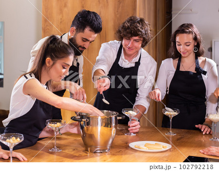 Chef teaching trainees how to make ice cream. Cooking tasty ice cream dessert made from chocolate and vanilla in glass bowl 102792218