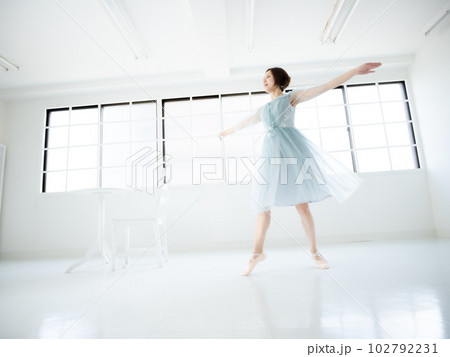 窓のある明るい室内でバレエの練習をする女性 102792231