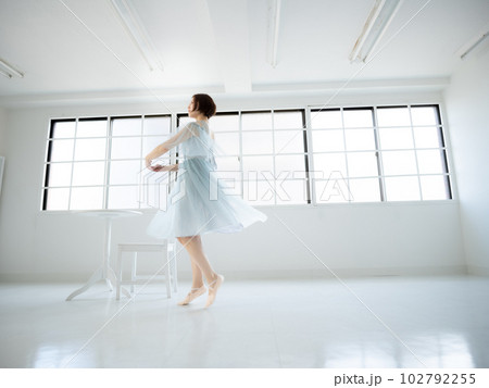 窓のある明るい室内でバレエの練習をする女性 窓のある明るい室内でバレエの練習をする女性 102792255