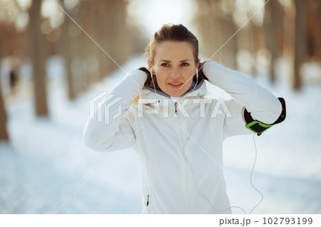 happy healthy woman in white jacket with headphones 102793199
