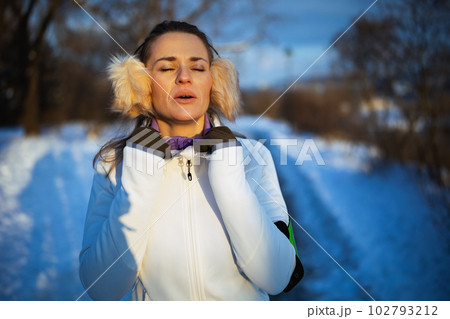healthy woman in white jacket catching breath after exercise healthy woman in white jacket catching breath after exercise 102793212