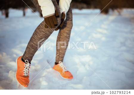 Closeup on woman in white jacket having leg pain Closeup on woman in white jacket having leg pain 102793214