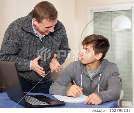 Father scolds son for poor grades in school 102796838