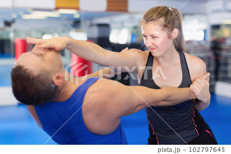 Fitness woman and her trainer are exercise punches Fitness woman and her trainer are exercise punches 102797645