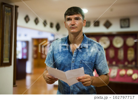 Man visiting museum with leaflet Man visiting museum with leaflet 102797717