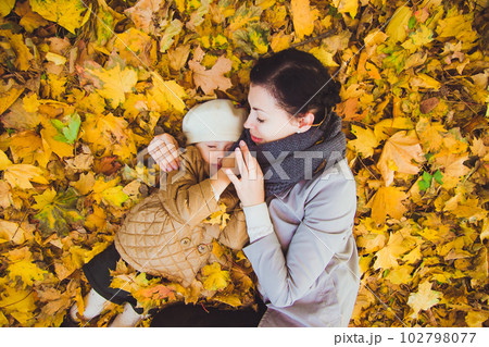 Young mother and her daughter have fun at autumn 102798077