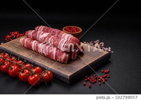 Raw minced meat wrapped in bacon with salt and spices or cevapcici Raw minced meat wrapped in bacon with salt and spices or cevapcici 102799057