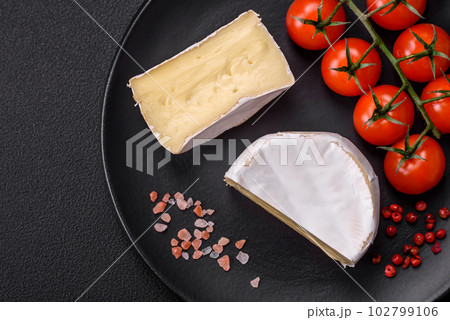 Delicious fresh brie cheese in the form of a mini head with cherry tomatoes 102799106