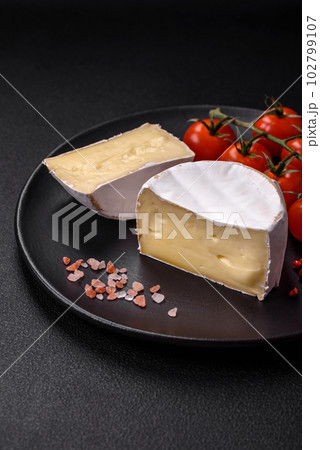 Delicious fresh brie cheese in the form of a mini head with cherry tomatoes Delicious fresh brie cheese in the form of a mini head with cherry tomatoes 102799107