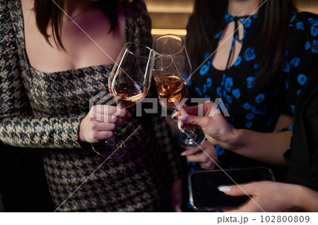 Clinking glasses with alcohol and toasting, party. 102800809