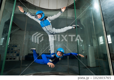 A man and a woman enjoy flying together in a wind tunnel. Free fall simulator 102803765