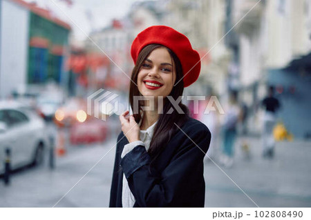 Happiness woman jumps and runs, follow me walks walks in the city against the backdrop of office buildings, stylish fashionable vintage clothes and make-up, spring walk, travel. 102808490