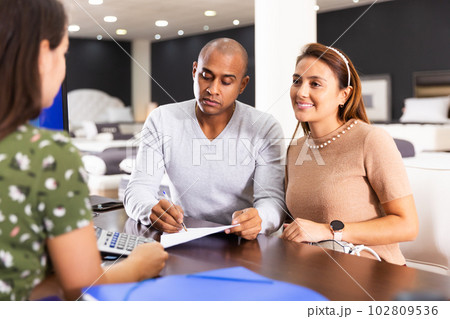 Couple talking to administrator of furniture store 102809536