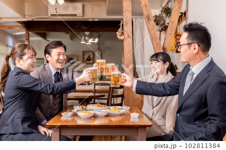 居酒屋で忘年会・新年会・飲み会・宴会をする仕事仲間・同僚・上司部下の男女 102811384