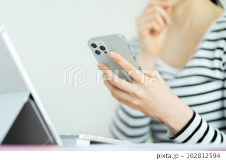 スマホを操作する若い女性　スマホを操作する女性の手元 102812594