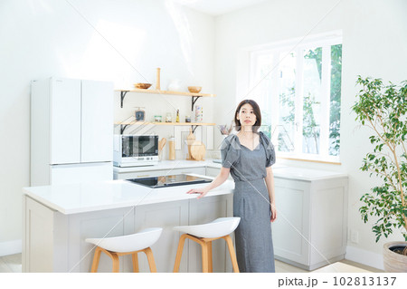 キッチンで佇む若い女性 102813137