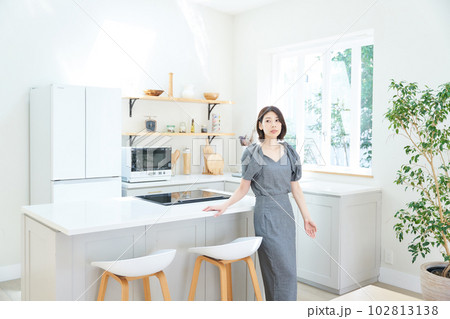 キッチンで佇む若い女性 102813138