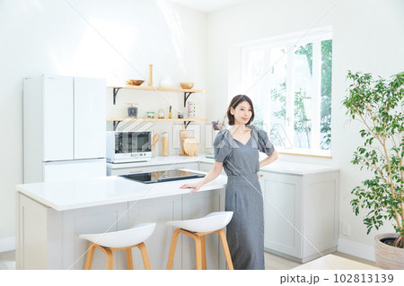 キッチンで佇む若い女性 102813139