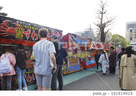 浅草寺の縁日は日本人も外国人も気ままに食べ歩く。楽しくおしゃべりしながら食べる着物のカップルも 浅草寺の縁日は日本人も外国人も気ままに食べ歩く。楽しくおしゃべりしながら食べる着物のカップルも 102814028