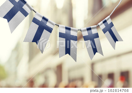 A garland of Finland national flags on an abstract blurred background 102814708
