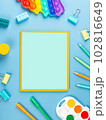 close-up of a paper notebook with blank sheets, a pen, a pencil and a paper clip on a blue background 102816649
