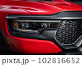Red car headlights. Exterior detail. Close up detail on one of the LED headlights modern car. 102816652