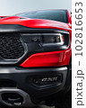Red car headlights. Exterior detail. Close up detail on one of the LED headlights modern car. 102816653