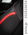 close-up black and red  perforated leather car seat. Skin texture 102816654