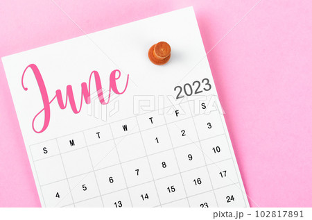 A June 2023 calendar and wooden push pin on pink colour background. A June 2023 calendar and wooden push pin on pink colour background. 102817891