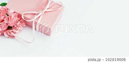 Pink gift box with tender pink carnation flowers. Gift or holiday concept. Mothers Day, birthday wedding or St Valentines day with copy space. Minimal 102819006