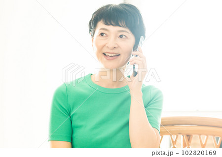 リビングで電話をするミドルの女性 リビングで電話をするミドルの女性 102820169