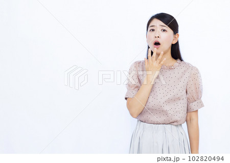 白い背景の前でビックリしている30代の女性 白い背景の前でビックリしている30代の女性 102820494