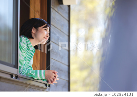 窓から顔を出す若い女性 102824131