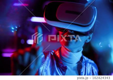 happy trendy woman in vr headset exploring metaverse 102824343