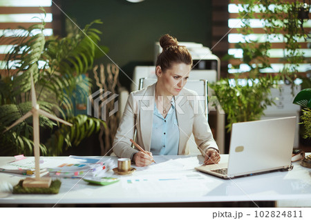 business woman in light business suit in green office business woman in light business suit in green office 102824811