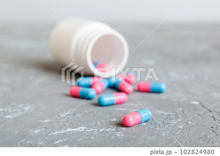 plastic medicine bottle with capsules of pills on colored background. Online pharmacy. Painkiller medicine and antibiotic drug resistance concept. Pharmaceutical industry 102824980