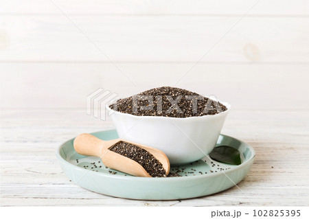 Chia seeds in bowl and spoon on colored background. Healthy Salvia hispanica in small bowl. Healthy superfood 102825395