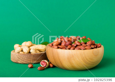 Fresh healthy peanuts in bowl on colored table background. Top view Healthy eating bertholletia concept. Super foods 102825396