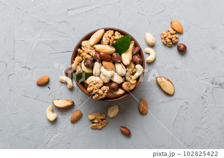 mixed nuts in bowl. Mix of various nuts on colored background. pistachios, cashews, walnuts, hazelnuts, peanuts and brazil nuts mixed nuts in bowl. Mix of various nuts on colored background. pistachios, cashews, walnuts, hazelnuts, peanuts and brazil nuts 102825422