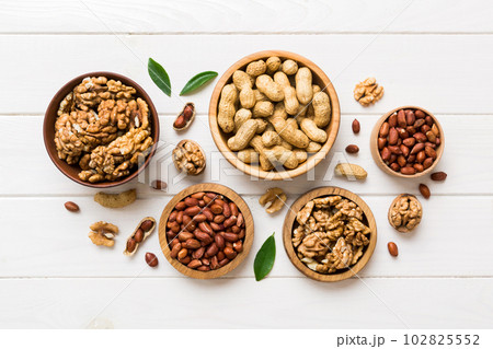 Walnut kernel halves, in a wooden bowl. Close-up, from above on colored background. Healthy eating Walnut concept. Super foods with copy space 102825552
