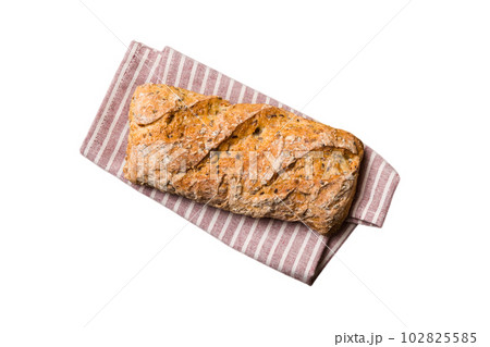 Freshly baked delicious french bread with napkin isolated on white background top view. Healthy white bread loaf 102825585