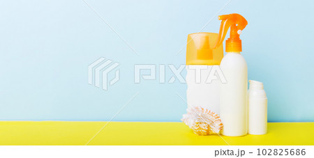 Beach accessories. Moisturiser sunscreen suntan lotion bottle for UVB skincare protection in summer with seashells on colored background. Mock up with copy space 102825686