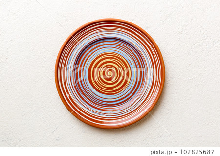 Top view of empty colorful plate on cement background. Empty space for your design Top view of empty colorful plate on cement background. Empty space for your design 102825687