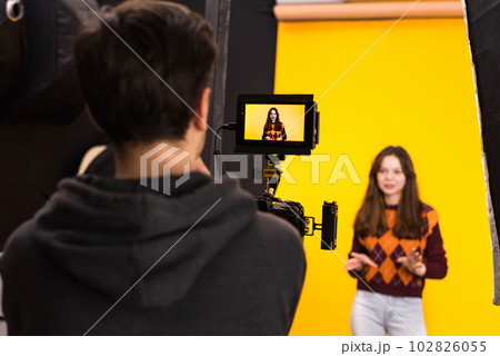 Professional photographer shooting a young woman 102826055