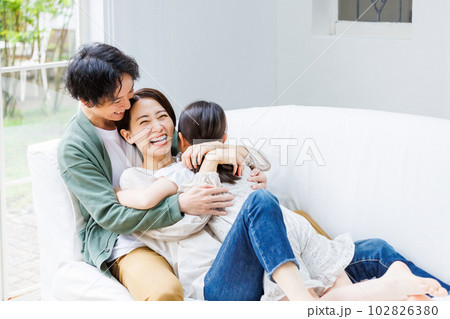 ソファでくつろぐ若い家族 102826380