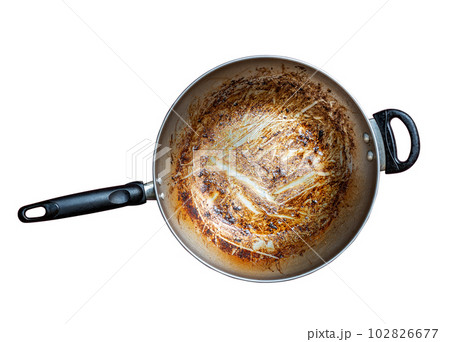 Top view of iron frying pan with burning mark, oily stains after cooking. Ingrain burning on iron pan, black handle, big area of oily stains, burnt black blemish. Isolated image on white background. 102826677