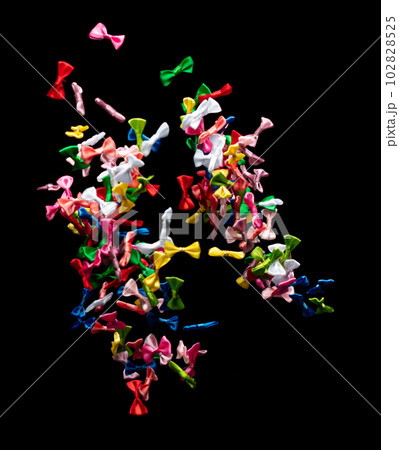 Bows flying in air. Many small ribbon in red, blue, pink, yellow throw explosion. Small Bow floating abstract black background isolated, high speed shutter freeze action Bows flying in air. Many small ribbon in red, blue, pink, yellow throw explosion. Small Bow floating abstract black background isolated, high speed shutter freeze action 102828525